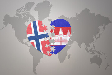 puzzle heart with the national flag of norway and cambodia on a world map background. Concept.