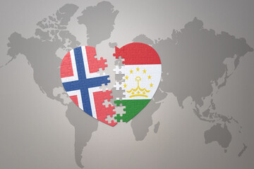 Fototapeta premium puzzle heart with the national flag of norway and tajikistan on a world map background. Concept.