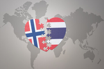puzzle heart with the national flag of norway and thailand on a world map background. Concept.