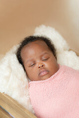 African baby girl napping wrapped up studio closeup