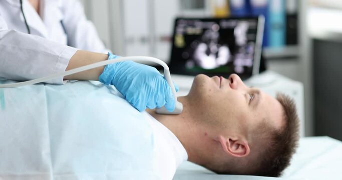 Man examine thyroid gland with ultrasound probe in medical office