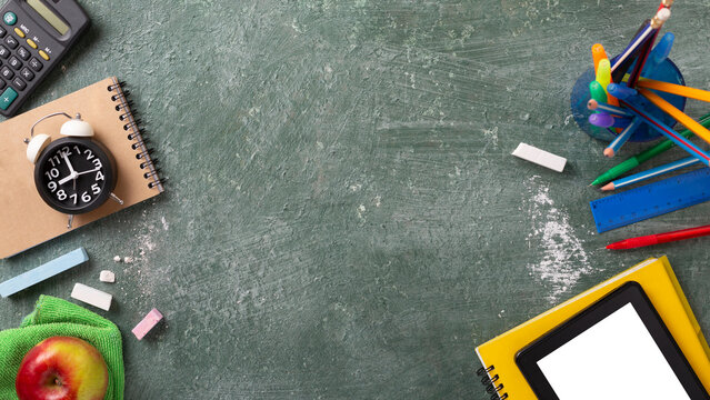 School background with school supplies and copy space. Top view, pens and pencils, notebooks, green chalk board