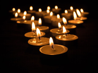 The fire burns in memory of those who died in the war. International Day of Remembrance. The concept of memory of the dead. Burning candles on a black background.