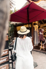young hispanic woman from the back walks in a market in the mexican caribbean
