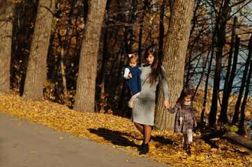 Fototapeta premium Mother with two daughters at autumn park.