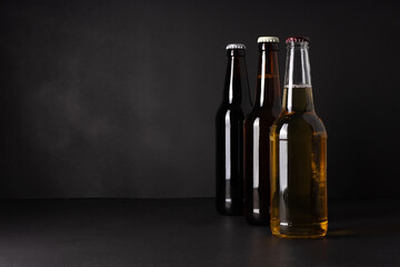 bottles with craft beer on a black background.  Ale or lager from pilsner malt.  homemade home-brewed beer. - obrazy, fototapety, plakaty