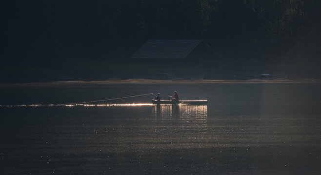 Father and son fishing on the lake in the early morning
