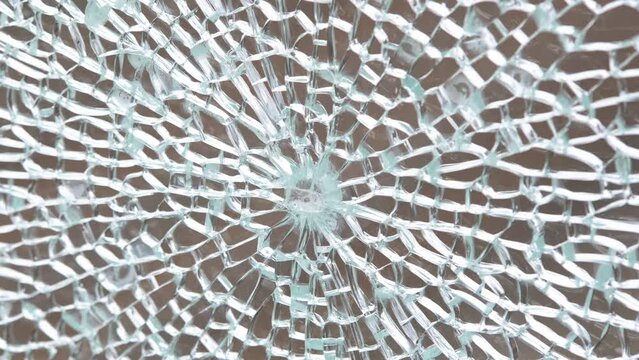 Broken tempered glass abstract background texture, shattered glass window object structure, bullet hole macro detail extreme closeup, nobody. Damaged cracked glass pane panel simple concept, no people