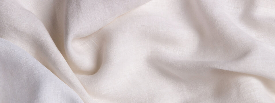 White crumpled linen fabric texture background. Natural linen organic eco textiles canvas background. Two shades of white color linen cloth material. Top view, copy space