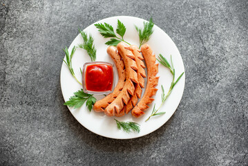 grilled sausages on a white plate on a stone background 