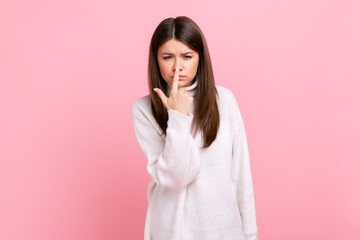 Pretty girl pointing finger at nose, showing lie gesture, blaming and suspicion you, body language,...