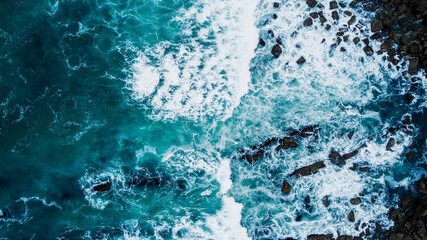 WAVES BREAKING ON ROCKS IN THE SEA OF THE COAST OF THE BASQUE COUNTRY FROM DRONE IN AERIAL VIEW