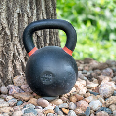 Naklejka na ściany i meble heavy iron kettlebell in a backyard - outdoor fitness concept