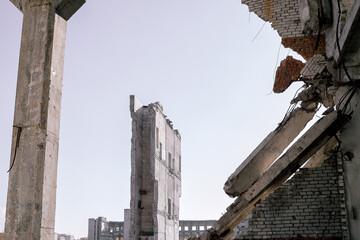 View through the destroyed wall on the remains of buildings against the background of a featureless...