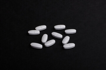 a pile of pills lies on a black background