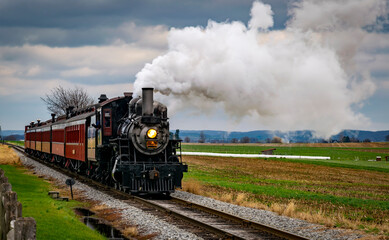 A Antique Restored Steam Engine and Coaches Approach Thru Corn Fields on a Sunny Day