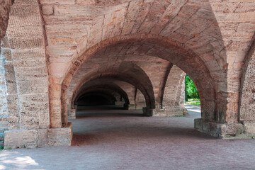 Stone arch made of red stone with columns