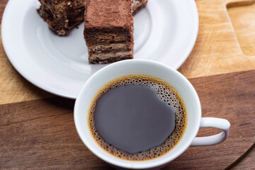 Uma xícara de café com palha italiana sobre superfície de madeira.