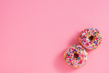 strawberry donuts with jimmies on pink background