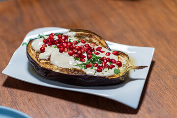 Grilled aubergines with tahini sauce and pomegranate seeds. High quality photo
