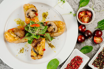 Snack of toasted bread with melted cheese and mushrooms on concrete background