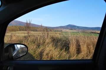 low, forested mountains, Ślęża mountain, Poland, seen from a car window - obrazy, fototapety, plakaty