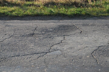 cracked asphalt and green roadside