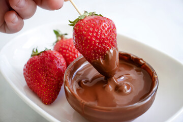 Fresh strawberries in chocolate on a light background