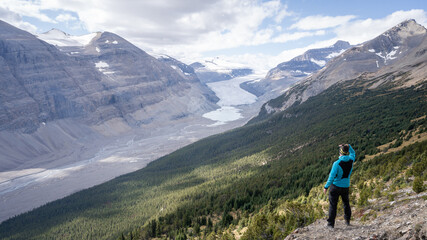 Fototapeta na wymiar Male hiker enjoying the view on untouched alpine valley with glacier on its end, Jasper, Canada