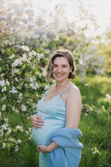 Fototapeta na wymiar Middle-aged beautiful pregnant woman dreaming about child outdoors. Happy expectant thinking about baby and enjoying her future life. Motherhood, pregnancy, happiness, health care concept, copy space.