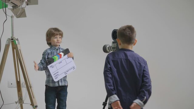 Children play at studio with loudspeaker, clapper and video camera, future stage director and actor