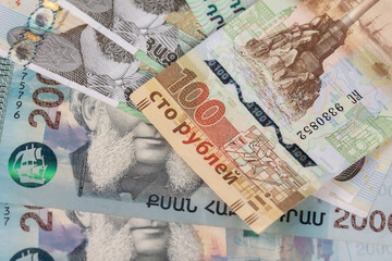 One hundred Ruble bill on top of Armenian currency.