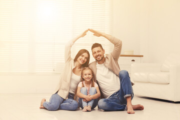 Happy family forming house roof with their hands at home. Insurance concept