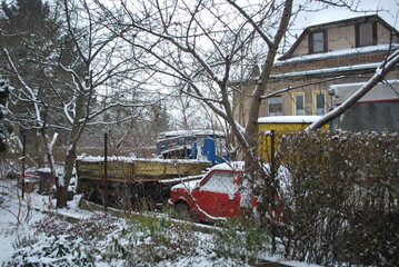 snowy garden, trees and shrubs, houses, cars, everything under the snow