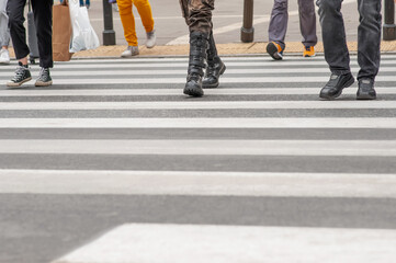 People crossing street in city, closeup view