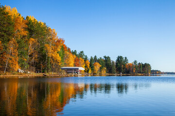 Typical Minnesota lake shoreline with dock and boat during autumn