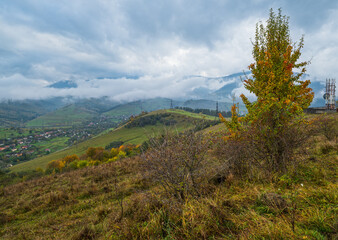 Cloudy and foggy day autumn mountains scene. Peaceful picturesque traveling, seasonal, nature and countryside beauty concept scene. Carpathian Mountains, Ukraine.