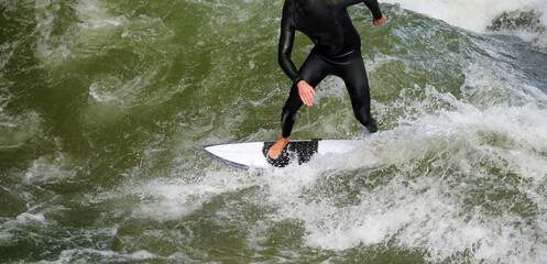 Young surfer with surfboard on the water