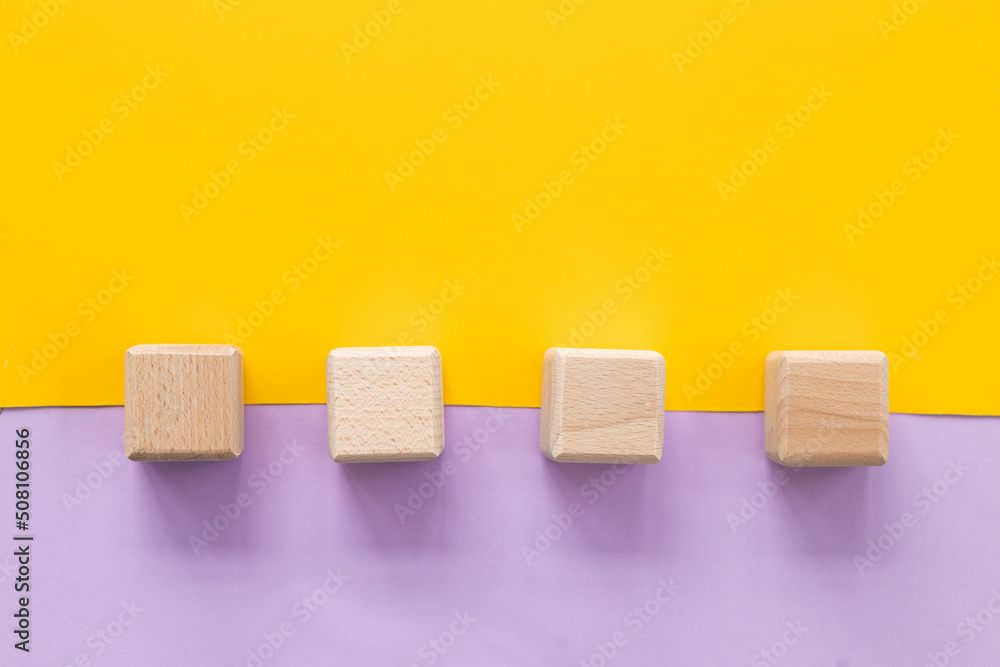 Wall mural Wooden cubes on yellow-pink background