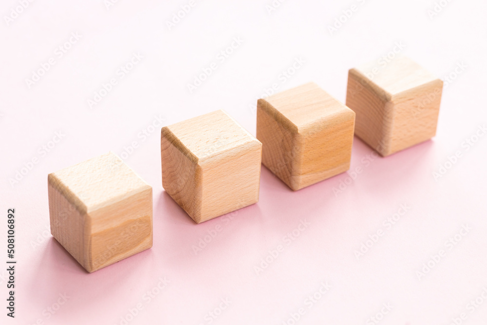 Wall mural Wooden cubes on yellow-pink background