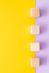 Wooden cubes on yellow-pink background