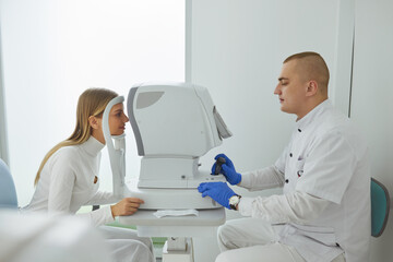 Eye Test. Optometrist Testing Woman Eyesight On Modern Equipment. Side View of Optometrist Giving...