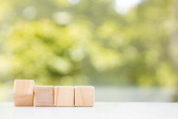 Wooden geometric shapes cubes isolated on a green summer background