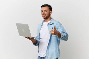 Joyful smiling tanned handsome IT professional man in casual basic t-shirt hold laptop show thumb up posing isolated on white studio background. Copy space Banner Mockup. Electronics repair concept