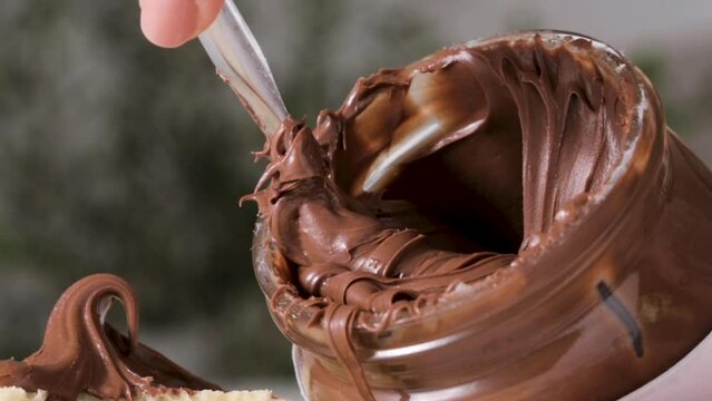 chocolate paste. Nut-chocolate paste for breakfast and favorite children's food. Closeup texture of pasta and gooey chocolate mixture. High quality 4k footage. Ideal for advertising and social posts
