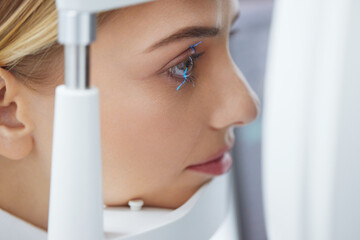Eyesight Exam. Woman Checking Eye Vision On Optometry Equipment. Close-Up Portrait of Girl Have Vision Check Up with Binocular Slit-lamp at Eye Test Machine