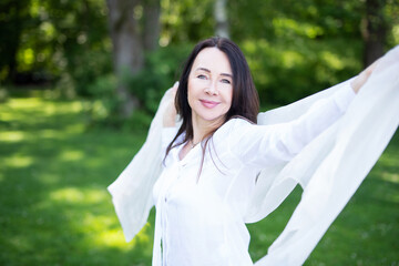 Attraktive Frau im mittleren Alter posiert mit einem weißen Tuch, Best Ager 
