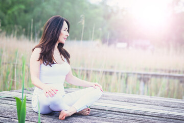 Attraktive Frau macht Yoga- Übungen draußen in der Natur 