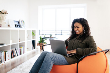 Portrait of smiling black woman using laptop at home