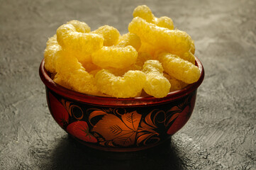 Sweet airy corn sticks in a beautiful bowl on a gray background. Front view, selective focus